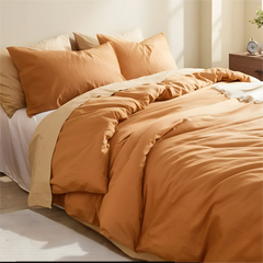 Top down view of orange duvet with four pillows arrangement.