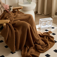 Person Using Brown Knitted Throw Blanket on Wood Chair