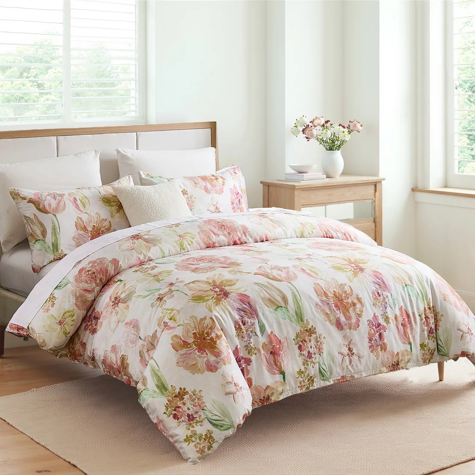 Full view of the pink floral comforter set in a bright bedroom