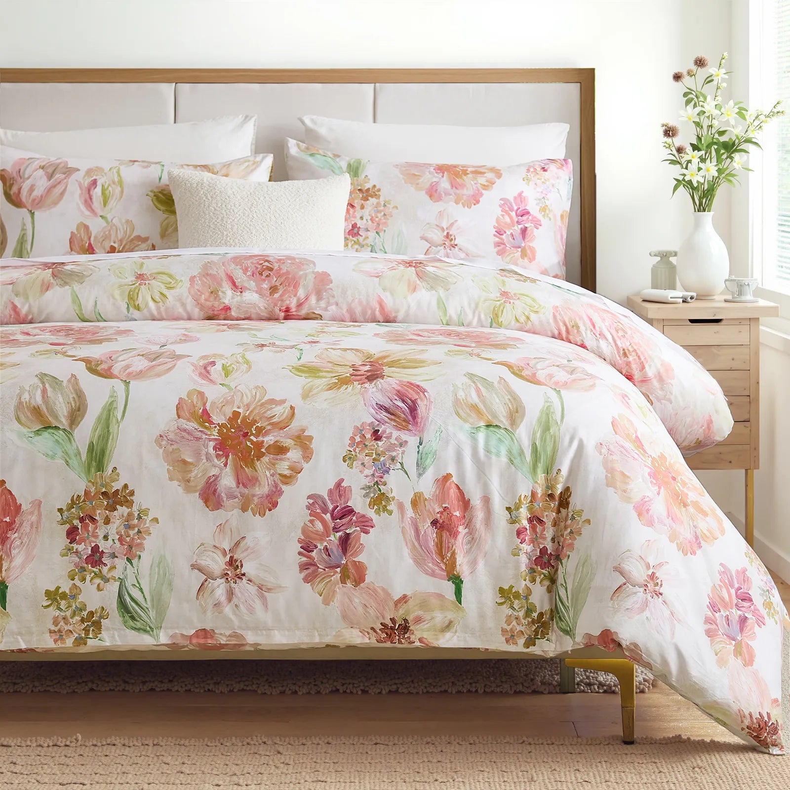 Pink floral comforter set styled in a bedroom with natural light