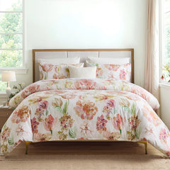 Pink floral cotton comforter set on a bed with a wooden headboard