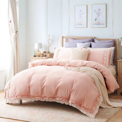 Full view of the pink ruffled cotton comforter set on a bed.