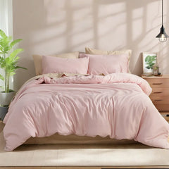 Front flat-lay view of a pink solid cotton duvet fully spread on the bed with pillows on both sides, soft natural light from the window.