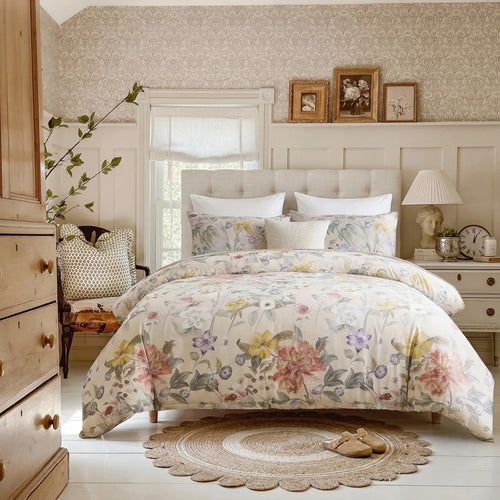 provence meadow blossom duvet cover set styled on bed with vintage iron headboard