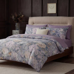 Side angle view of bed with purple floral and lace bedding set