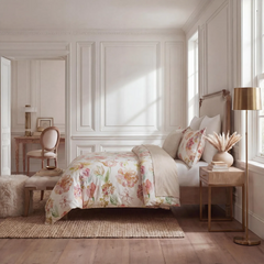 Side profile of a styled bed with romantic floral print bedding