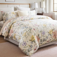 Close-up shot of the floral comforter on a bed with pillows
