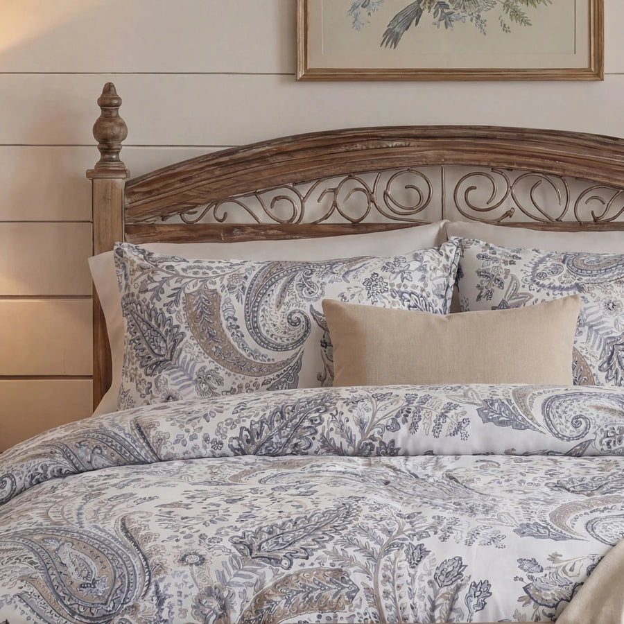 detailed view of dusty blue paisley print cotton pillow shams on a classic wooden bed frame