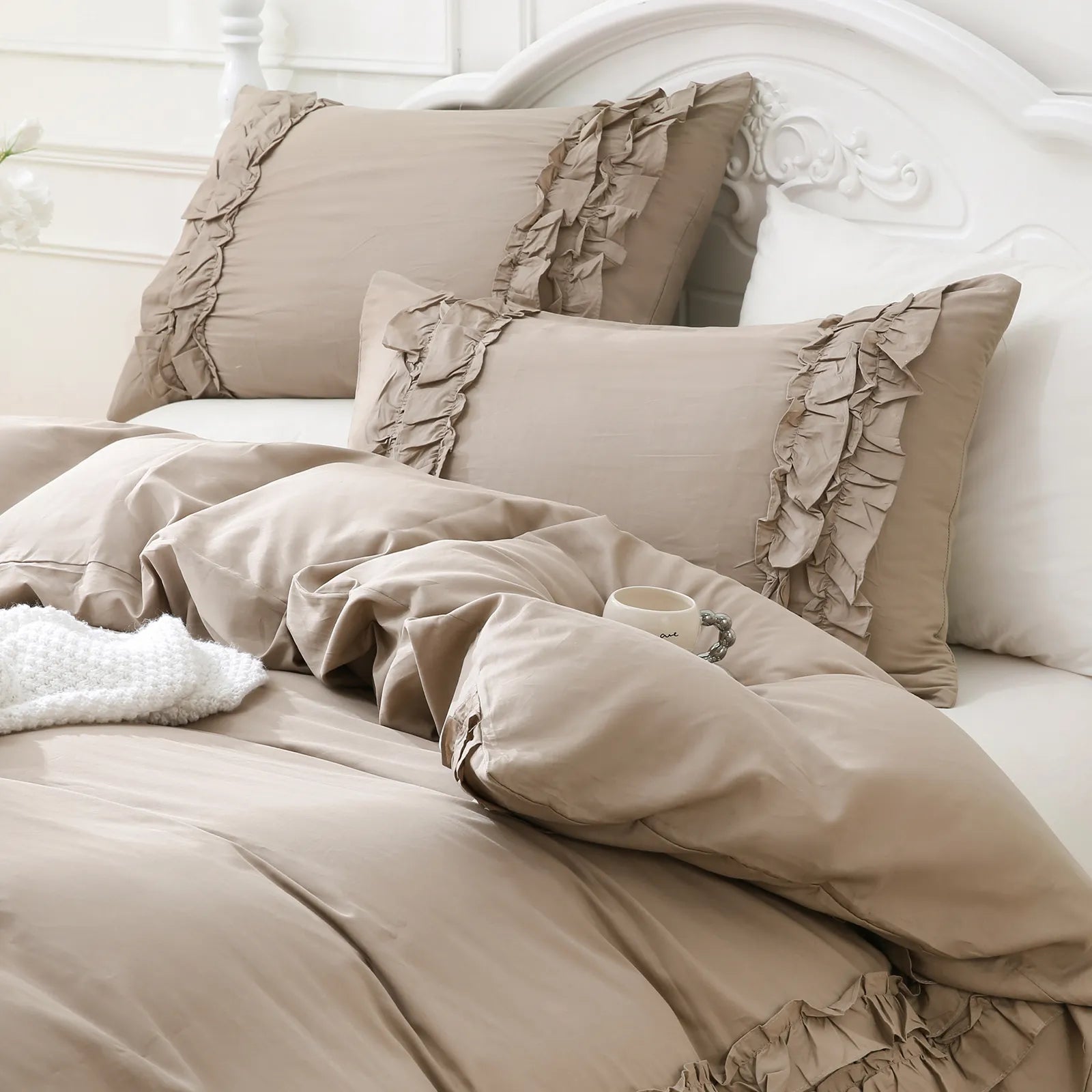 Close-up shot of the warm greige grey ruffled edge on the corner of the white comforter