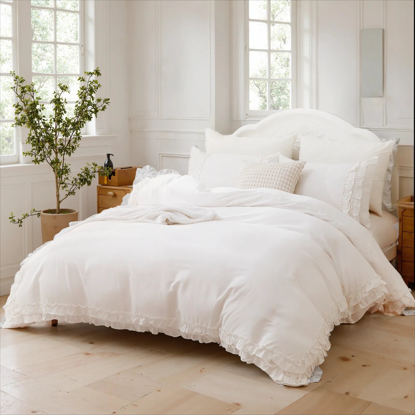 White cotton ruffle bedding on a bed with a carved headboard, featuring a textured throw pillow.