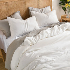 Overhead angled shot from the foot of the bed showing the white duvet's natural folds and the pillow arrangement.