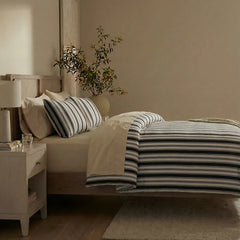 Side view of white black grey striped duvet and pillows