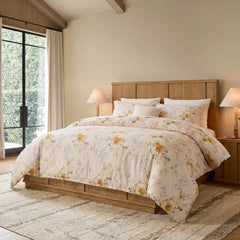 Angled shot of yellow garden floral duvet on a wooden bed