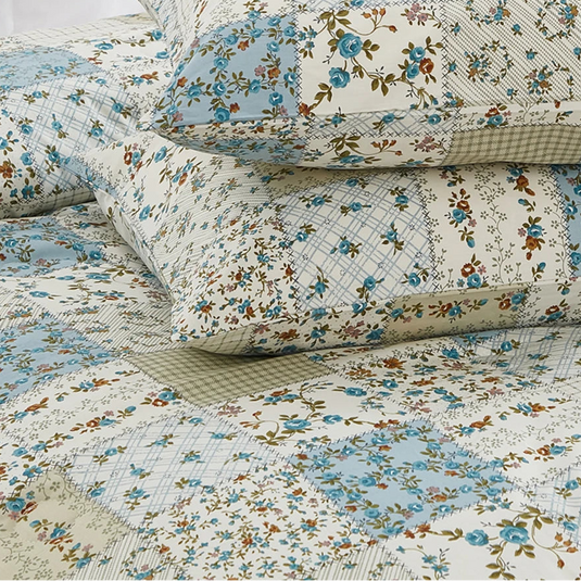 macro view of the artisanal patchwork motifs featuring blue roses and sage green gingham