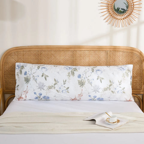 Full front view of a long cotton body pillowcase with a serene blue and grey watercolor floral print on a bed.