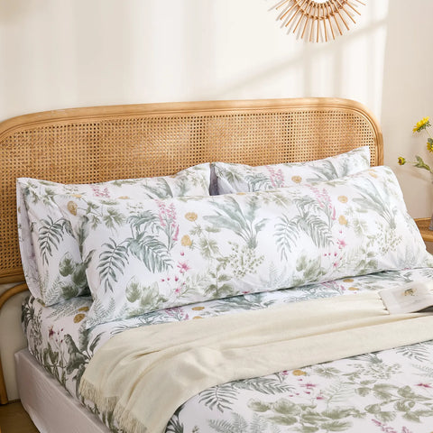 The long cotton tropical body pillowcase styled on the bed with a pair of matching standard pillowcases for a layered look.