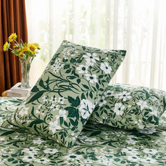 An angled shot of two olive green cotton pillowcases on a bed, with bright natural light from a nearby window and sun accent.