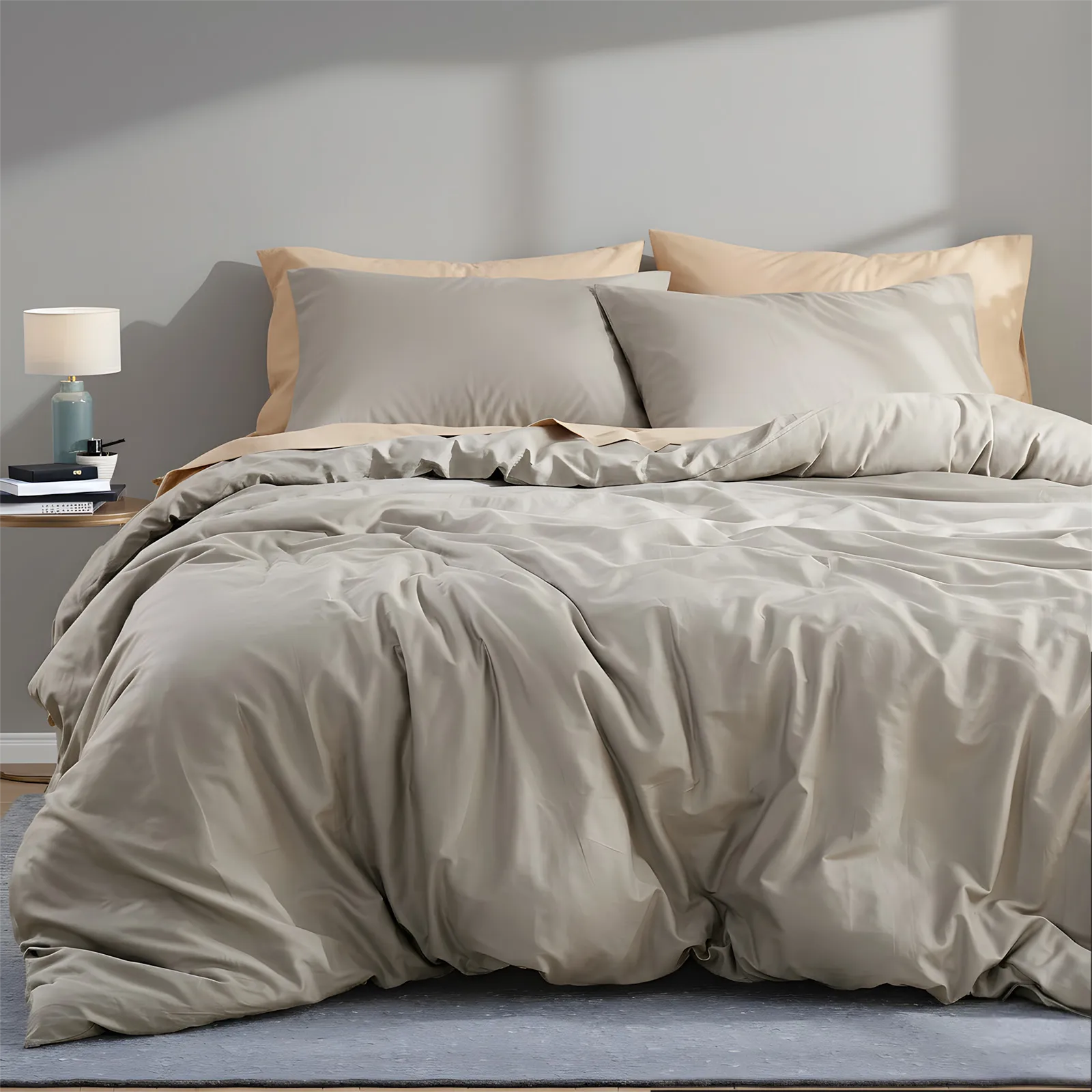 Overall view of beige grey duvet cover with four pillows on bed