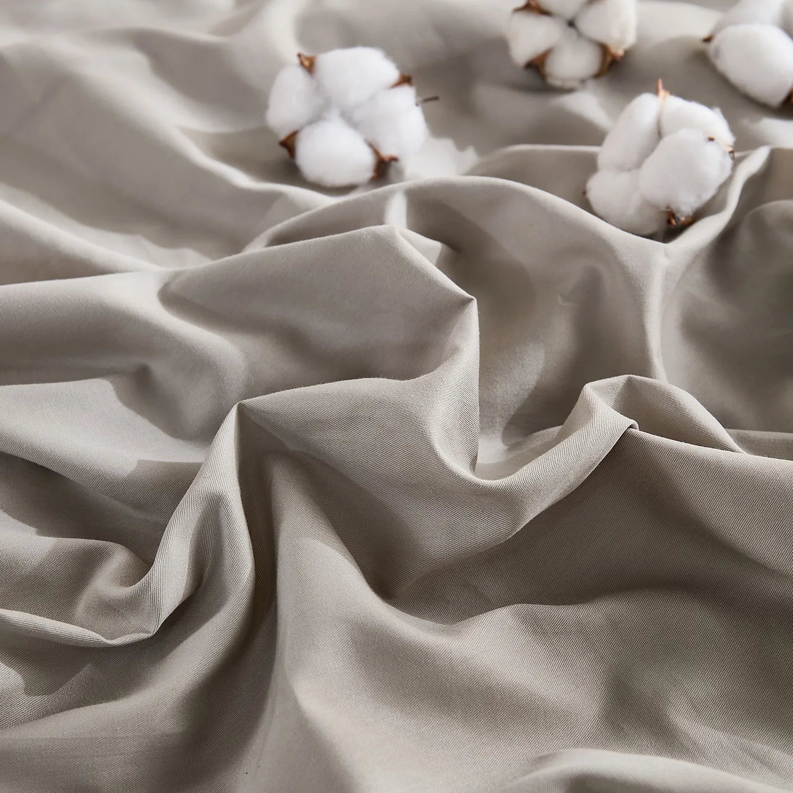 Close-up texture detail of beige grey duvet fabric with cotton accents