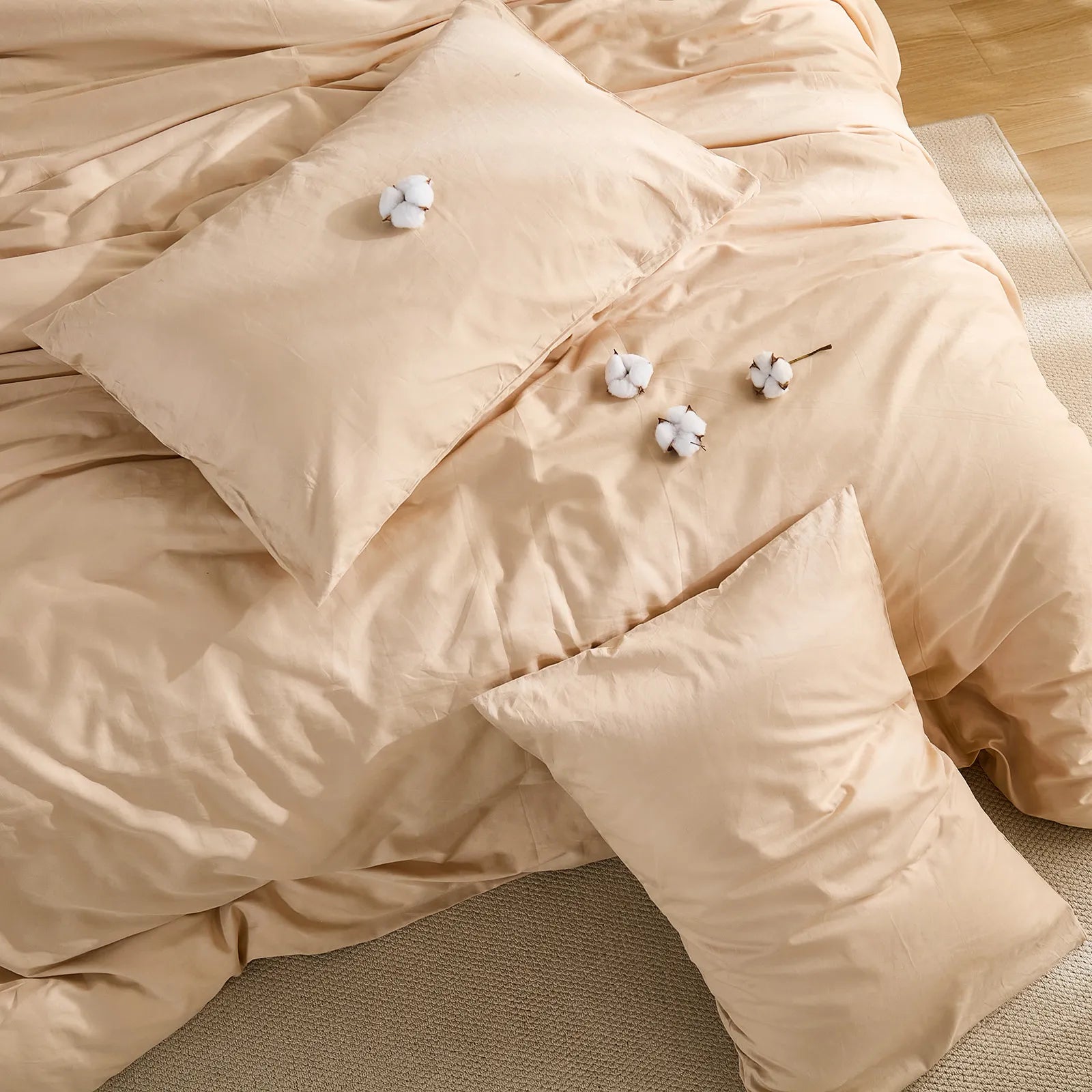 Top view of beige solid duvet with four cotton balls scattered on surface