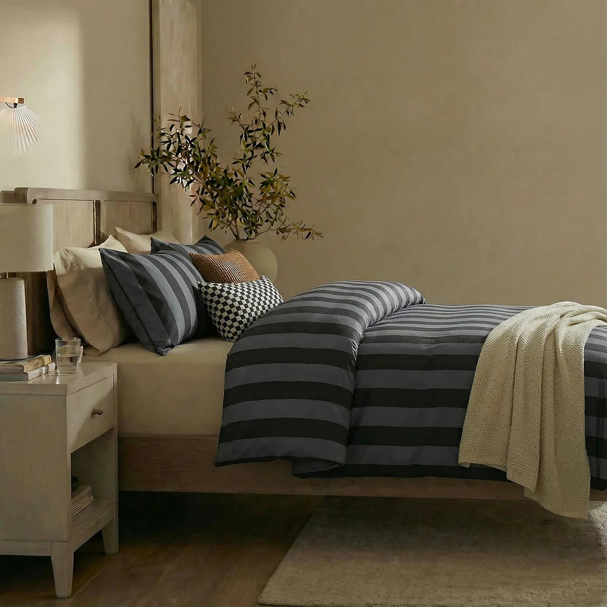 Side view of black and grey striped duvet and pillows