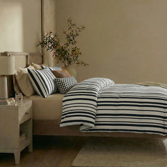 Side view of black and white striped duvet and pillows