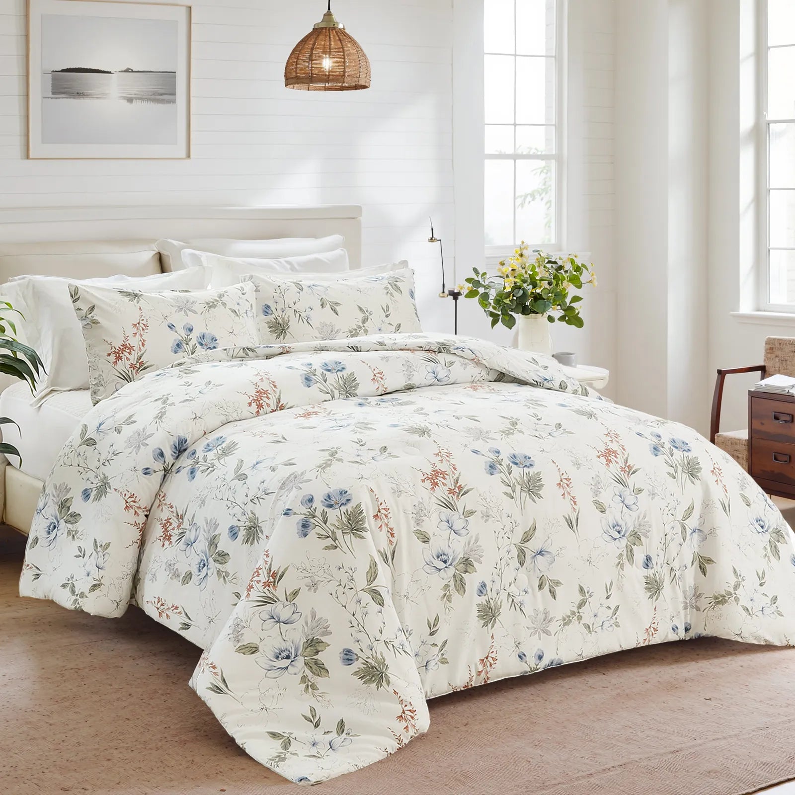 Bed with white floral comforter set in a bright bedroom with a woven light fixture and large windows.