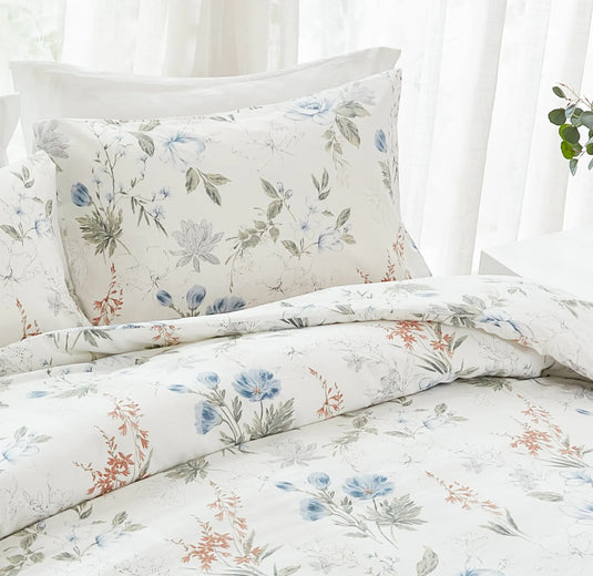 detailed view of the blue floral pillowcases on a bed with striped bedding