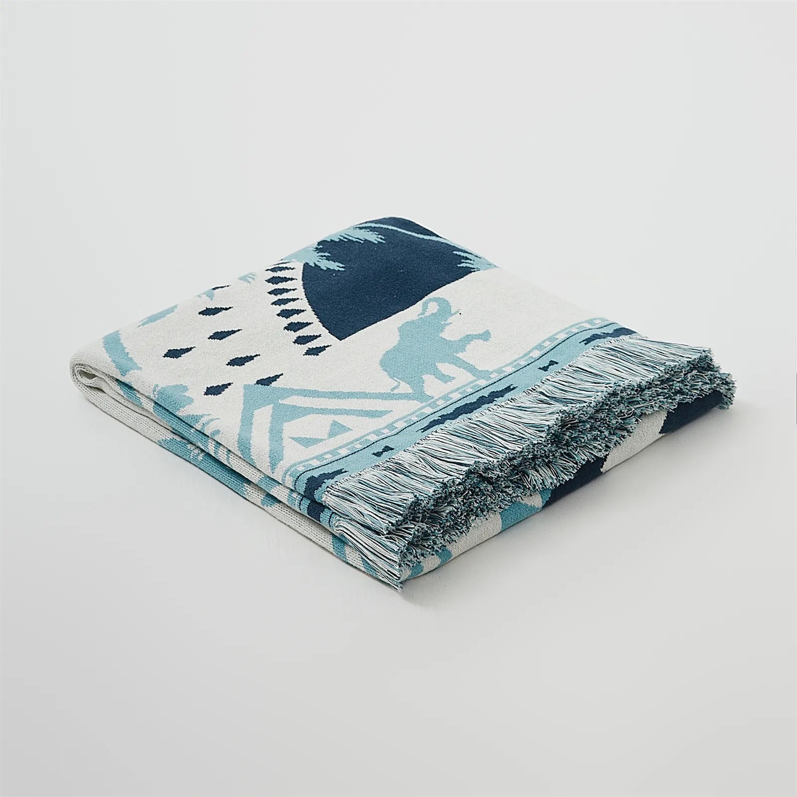 A studio shot of the Prussian blue 100% cotton tassel blanket, highlighting its premium feel and beautiful texture.