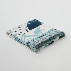 A studio shot of the Prussian blue 100% cotton tassel blanket, highlighting its premium feel and beautiful texture.