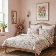 angled profile view of the blush peony cotton bedding set on a natural wood bed frame