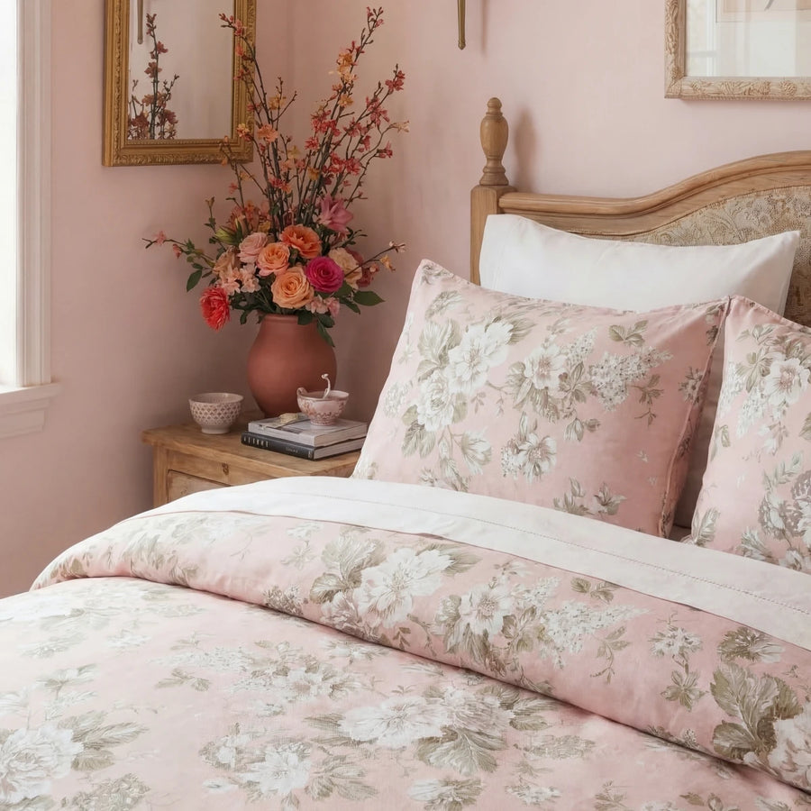 detailed side view of blush rose floral bedding styled with warm lamp light and flowers