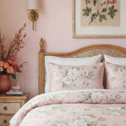 close-up of romantic peony print cotton pillowcases against a vintage wooden headboard