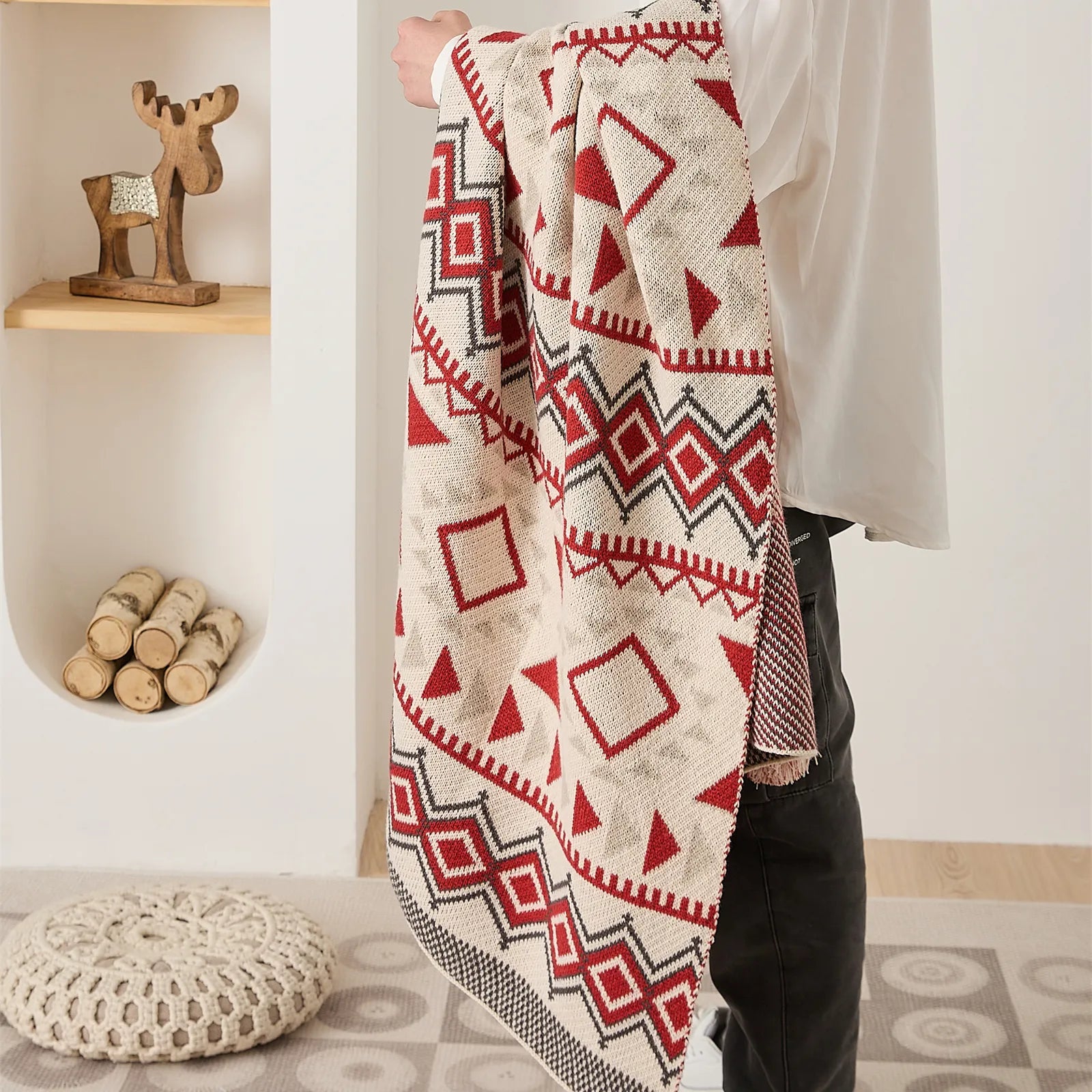 Man holding boho vintage knit throw blanket in red and cream geometric pattern lifestyle shot