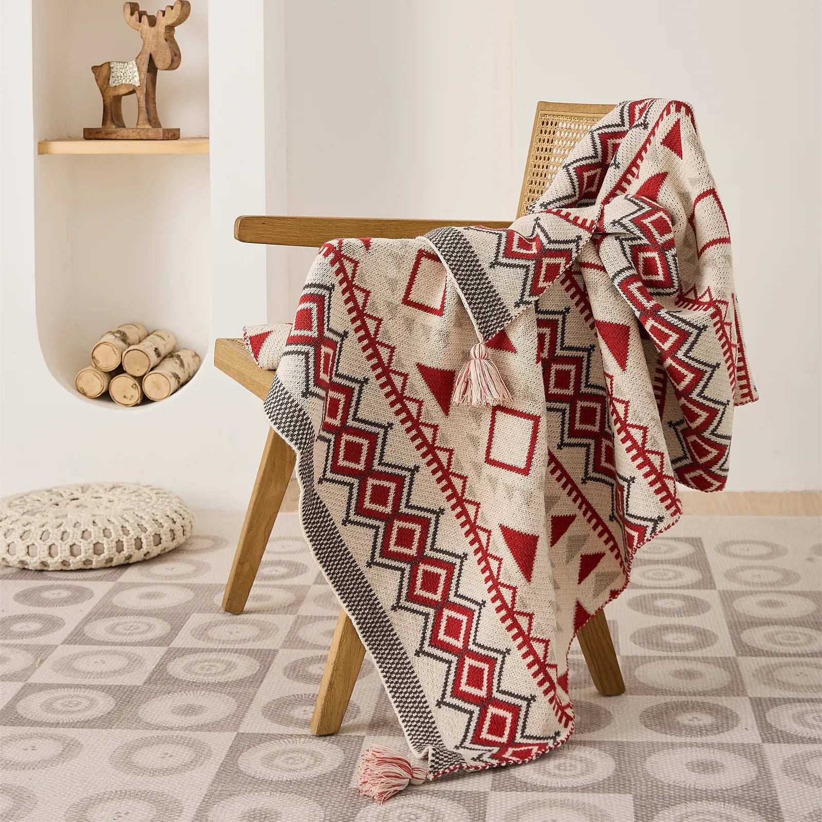 Boho rust red and cream knit throw blanket draped over a wooden rattan accent chair