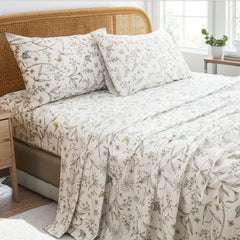 Close up view of cotton botanical floral sketch sheet set on bed with rattan headboard	