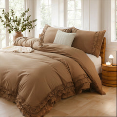 Cozy scene of a brown cotton double ruffle duvet cover on a bed with a lighted lamp and a mug on a round nightstand.