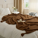 Brown Knitted Throw Blanket on Bed with Candle and Decorative Tray