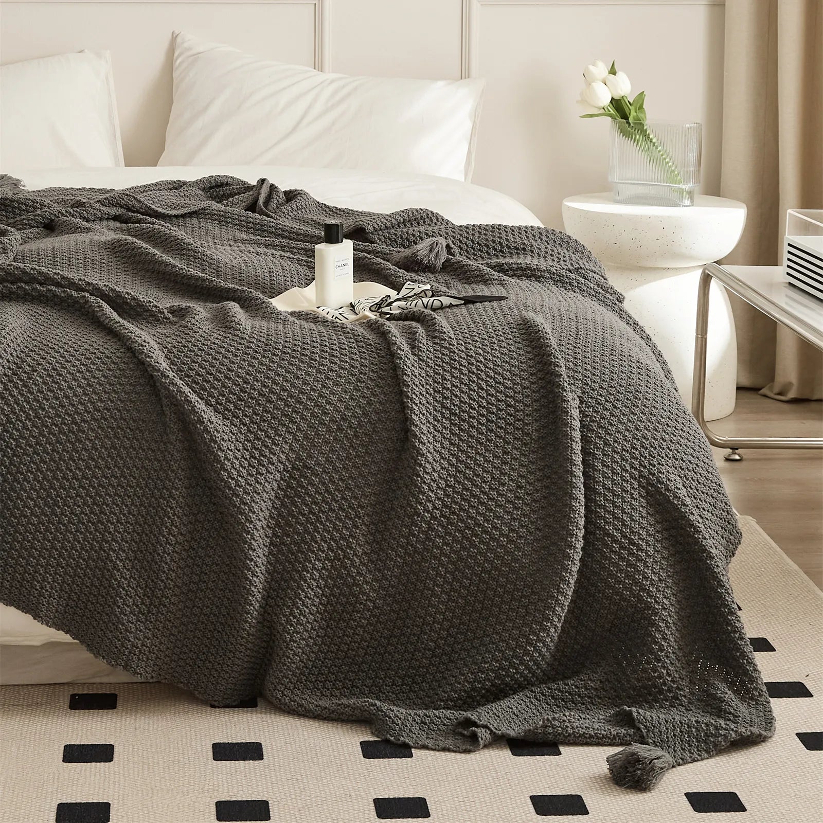 Charcoal Knitted Throw Blanket Draped Bedside with Perfume Bottle
