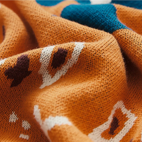 Detailed close-up of the orange bohemian jacquard cotton throw's weave and multi-color pattern detail.