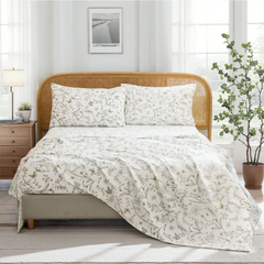 Full room view of cotton botanical sketch floral sheet set on bed with rattan headboard