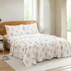 Wildflower botanical cotton sheet set draped on bed with light wooden headboard