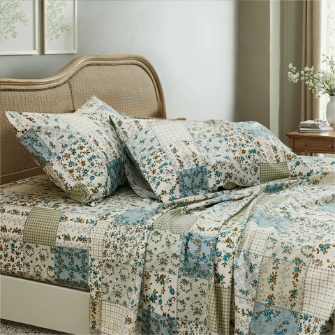 Country style cotton floral patchwork bedding set on bed, angle view	