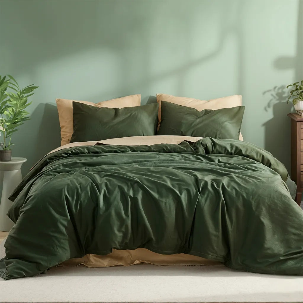 Full front view of a dark green solid cotton duvet on a full-size bed with green plants on both sides.