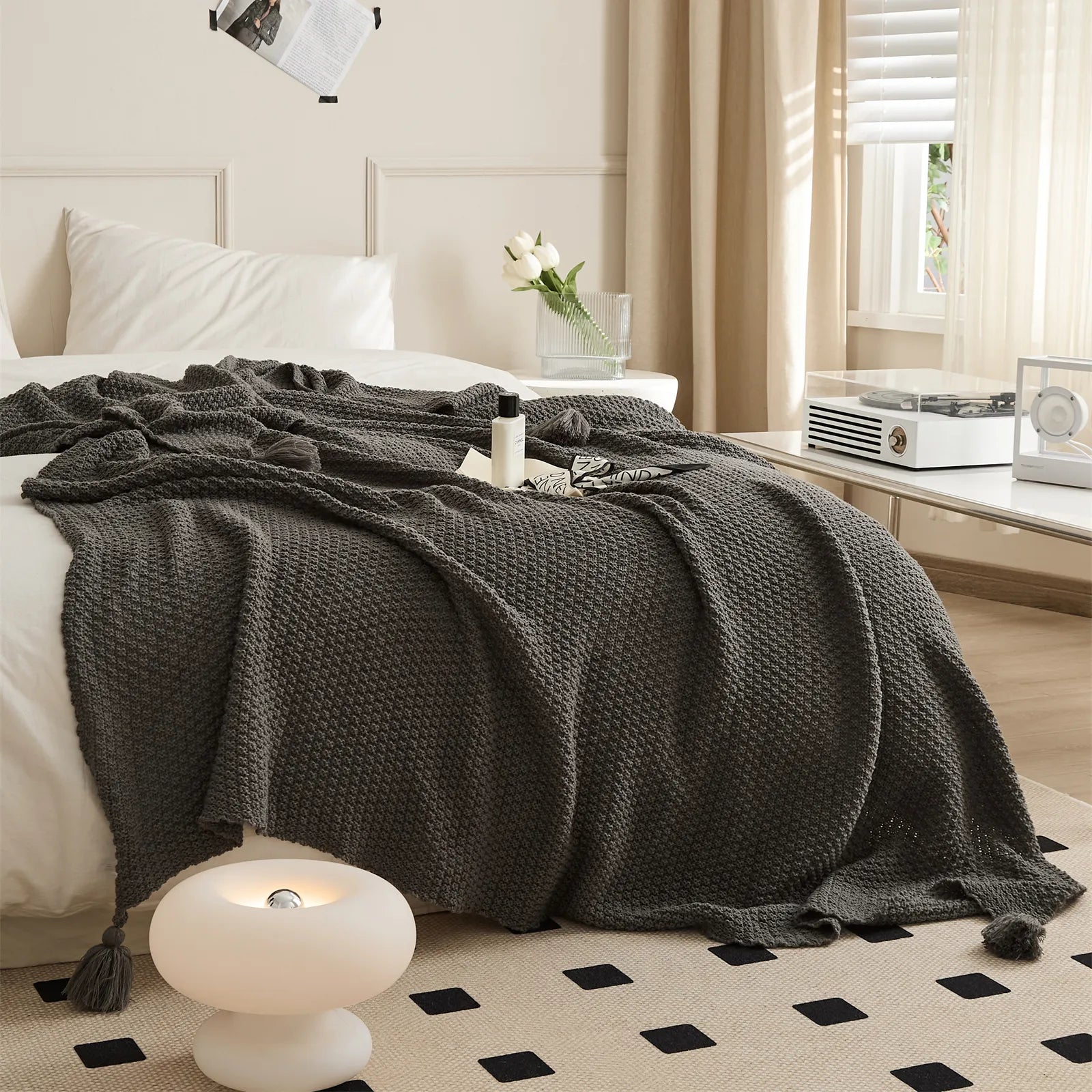 Dark Grey Knitted Throw Blanket Draped on Bed with Modern Lamp Decor