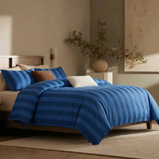 Angled shot of dark blue and deep blue  striped duvet cover on bed