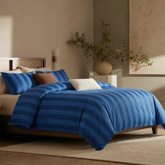 Angled shot of dark blue and deep blue  striped duvet cover on bed