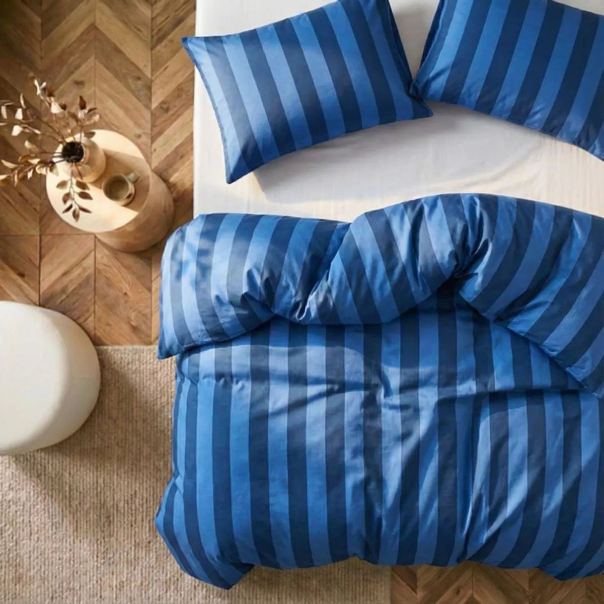 Overhead flat lay of dark blue and deep blue striped duvet and cases