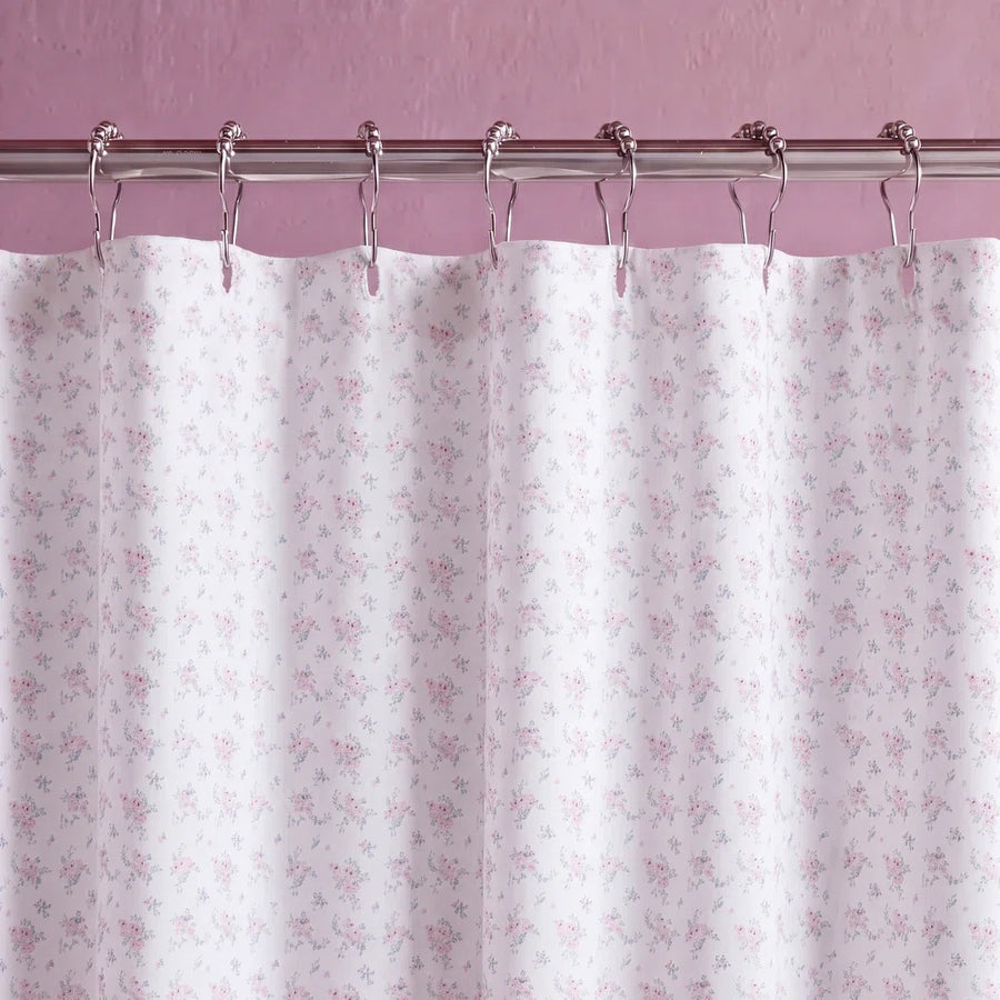 dreamy pastel shower curtain white metal rings mauve wall close up