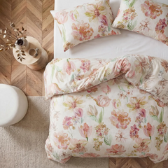 Top down view of floral print bed linen and pillows on wooden floor